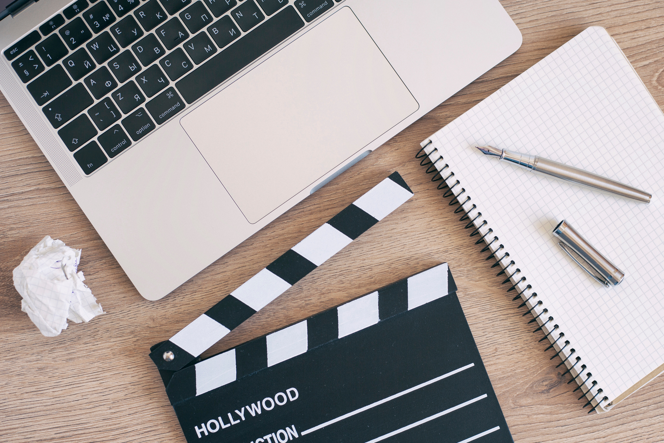 Video Editing,Movie clapper laptop and pencil notepad on the wood table top view